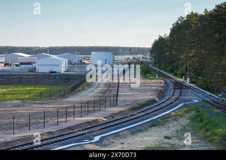 17 maggio 2024, Brandeburgo, Grünheide: I binari corrono lungo il bordo della foresta verso la parte orientale del sito Tesla Gigafactory. Giovedì sera, i rappresentanti municipali di Grünheide hanno approvato un piano di sviluppo che spiana la strada a un'espansione della fabbrica Tesla. Il produttore di automobili desidera espandere il proprio sito per includere un deposito merci e aree logistiche. Foto: Soeren Stache/dpa Foto Stock