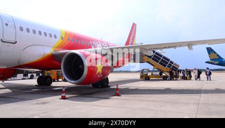 I passeggeri salgono a bordo, tramite le scale di imbarco dei passeggeri, un aereo Vietjet Air Airbus A321 all'aeroporto internazionale Tan Son Nhat, Saigon o ho chi Minh City Foto Stock