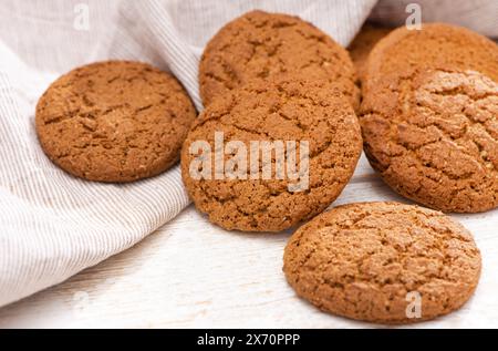 Biscotti di farinata d'avena appena sfornati su fondo rustico in legno. Primo piano dall'alto con un'illuminazione direzionale naturale. Foto Stock