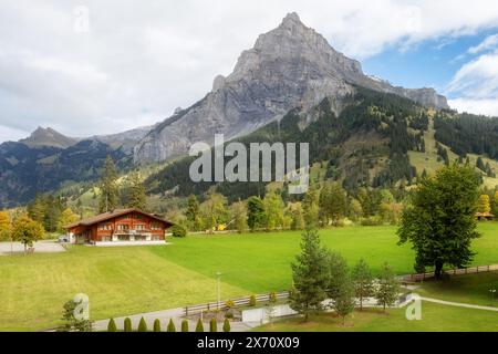 Chalet in legno in Kandersteg village, Canton Berna, Svizzera, Europa, Autunno alberi e Montagne Vista panoramica Foto Stock