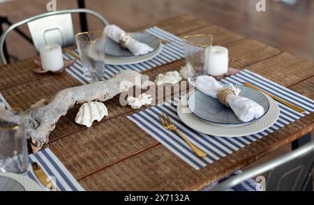 Un tavolo d'argento. piatti ed elettrodomestici in stile legno. ramo d'albero. tavolo, sedie. Foto Stock