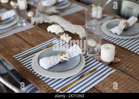 Un tavolo d'argento. piatti ed elettrodomestici in stile legno. ramo d'albero. tavolo, sedie. Foto Stock