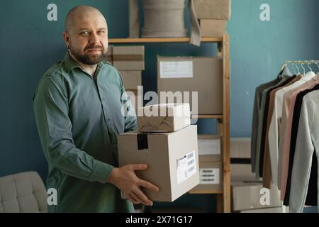 lavoratore maschile che tiene scatole di cartone. Accordi di consegna. Invio di pacchi ai clienti. Foto Stock