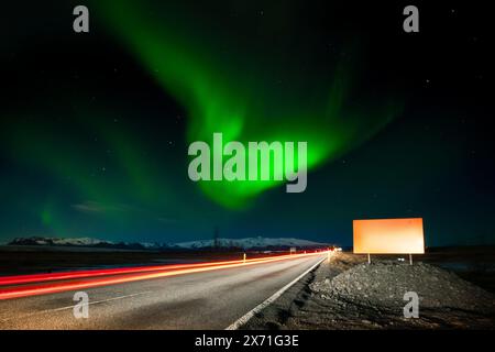 Copia spazio vuoto segnale stradale bianco in Islanda. Il pass per auto lascia sentieri leggeri sulla strada circolare d'oro islandese. Aurora boreale. Viaggio in auto e chasi Foto Stock