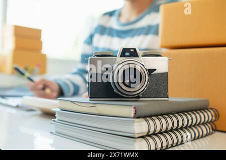 Una macchina fotografica d'epoca si siede su un tavolo in un ufficio e un libro si distingue sullo sfondo. Una videocamera vintage dal design semplice si trova su un tavolo Foto Stock