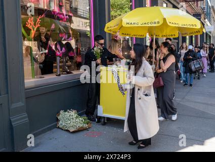 Gli acquirenti del negozio Marc Jacobs di Soho a New York si allineano per ricevere mazzi di margherite per la festa della mamma, sabato 11 maggio 2024. Daisy il nome della linea di fragranze di Jacobs. (© Richard B. Levine) Foto Stock