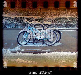 Una bicicletta innevata incatenata a un portabiciclette nel quartiere Chelsea di New York, marzo 2024. Fotografato su pellicola con una fotocamera instamatic. (© Richard B. Levine) Foto Stock