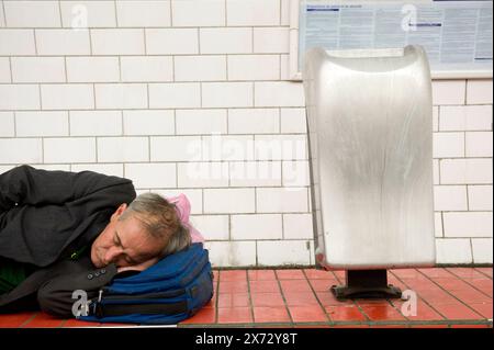 Senzatetto uomo che dorme senzatetto uomo che dorme vicino a un cestino pubblico e lettiera all'interno di una stazione della metropolitana. parigi, Francia. Stazione della metropolitana Parigi X Ile de France Francia Copyright: XGuidoxKoppesxPhotox Foto Stock