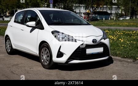 Minsk, Bielorussia, 17 maggio 2024 - Toyota Yaris bianca giapponese compatta è parcheggiata sulla strada. Vista laterale anteriore. Foto Stock