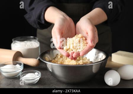 Donna con pasta frolla a tavola grigia, primo piano Foto Stock