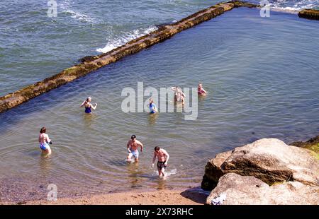 St Andrews, Fife, Scozia, Regno Unito. 17 maggio 2024. Meteo nel Regno Unito: St Andrews sta vivendo un'incredibile ondata di caldo primaverile. Sia la gente del posto che i turisti trascorrono la giornata a Castle Beach, godendosi il caldo sole di maggio, prendendo il sole e rinfrescandosi nella piscina all'aperto. Crediti: Dundee Photographics/Alamy Live News Foto Stock