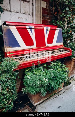 Un vecchio pianoforte dai colori della bandiera britannica con chiavi squallide sulla strada di Londra Foto Stock