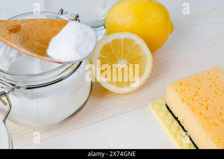 Aprire il vaso di bicarbonato con un cucchiaio di legno sopra, aceto e limone tagliato. vista dall'alto, spazio per il testo. Il concetto di rimozione organica delle macchie in cucina Foto Stock