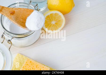 Aprire il vaso di bicarbonato con un cucchiaio di legno sopra, aceto e limone tagliato. vista dall'alto, spazio per il testo. Il concetto di rimozione organica delle macchie in cucina Foto Stock