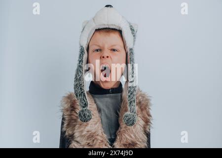 Ragazzo in costume da lupo ruggente, isolato su sfondo grigio Foto Stock