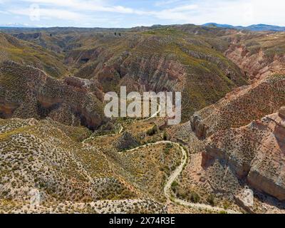 Ampie vedute di rocce e canyon collinari, attraversati da sentieri tortuosi, vista aerea, Los Coloraos, Grand Canyon dell'Andalusia, deserto di Gorafe, Granada, A. Foto Stock