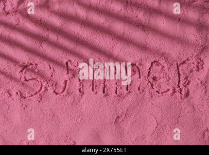 La parola Estate scritta a mano su una superficie di sabbia rosa con ombra tropicale di foglie di palma. Foto minimale delle vacanze estive. Sole e ombre. Foto Stock