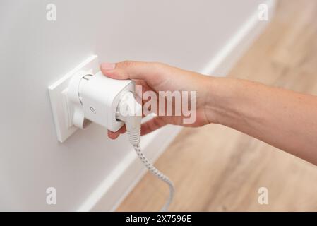 Utilizzo di prese Wi-fi Smart in una casa intelligente, controllo del consumo di elettricità Foto Stock