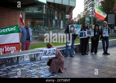 Madrid, Spagna. 17 maggio 2024. Un manifestante tiene uno striscione con immagini di persone assassinate in Iran, durante una protesta della comunità iraniana a Madrid, che si unisce all'azione globale di accendere le candele in memoria dei martiri del cammino della libertà e della rivoluzione delle donne, della vita, della libertà. Credito: SOPA Images Limited/Alamy Live News Foto Stock