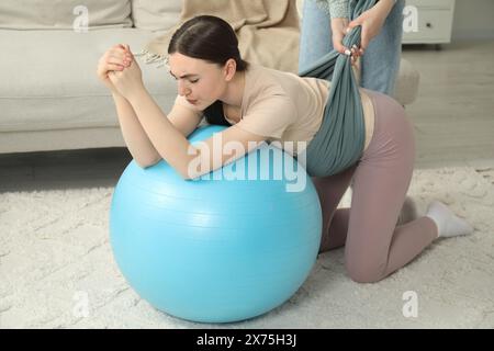 Doula lavora con una donna incinta a casa. Preparazione alla nascita del bambino Foto Stock