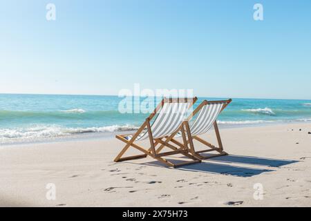 Sulla spiaggia, due sedie vuote di fronte all'oceano, in attesa dei visitatori Foto Stock