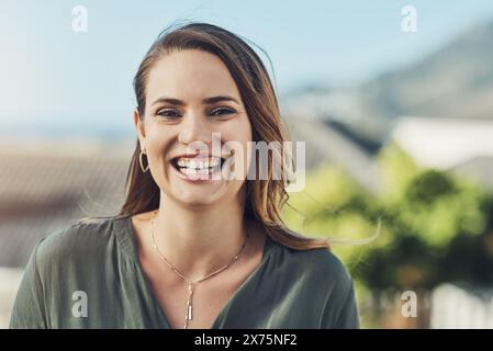 Ragazza, sorriso e ritratto all'aperto in natura per proprietà residenziali in vendita, listino e quartiere per il mercato immobiliare. Donna, agente immobiliare Foto Stock