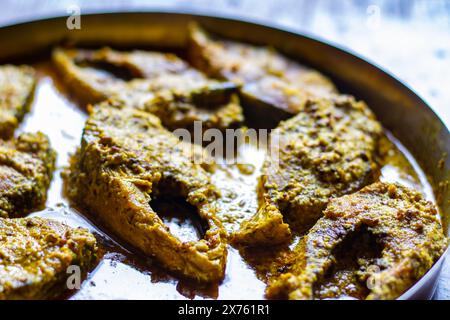 Sorshe ilish o hilsa curry di pesce cotto con semi di senape servito su un piatto. Pezzi di pesce sono visti in una ricca salsa gialla. Questo è un mestiere molto popolare Foto Stock