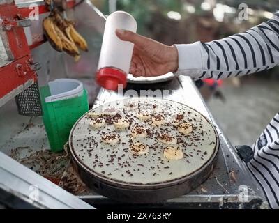 Giacarta, Indonesia - 6 maggio 2024 : primo piano di mani che fanno crepes di banana Foto Stock