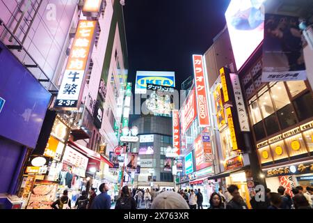 Folle di persone che si divertono la sera al famoso incrocio di Shibuya a Tokyo Foto Stock