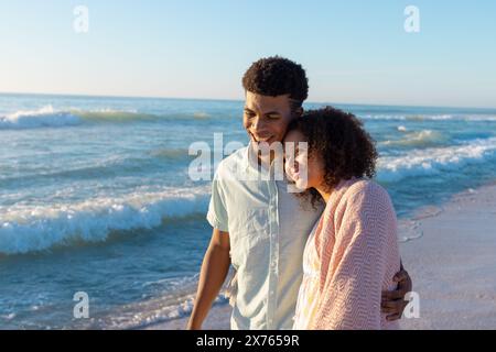 In spiaggia, coppie diverse che si abbracciano, camminano sulla sabbia Foto Stock