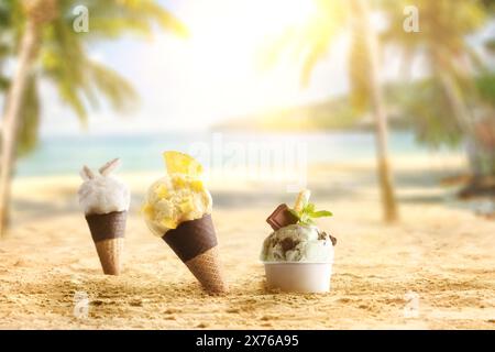 Sfondo con coni e un bicchiere di gelato per rinfrescarsi sulla sabbia su una calda spiaggia tropicale soleggiata. Vista frontale. Foto Stock