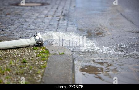 18 maggio 2024, Saarland, Saarbrücken: I tubi portano fuori dalle cantine di molte case e pompano l'acqua fuori. Forti piogge continue hanno causato numerose inondazioni e frane nel Saarland. Foto: Laszlo Pinter/dpa Foto Stock