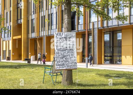 Uno striscione attaccato ad un albero da studenti manifestanti presso l'accampamento di protesta pro palestinese presso l'Università di Birmingham. Israel Hamas protesta di guerra. Foto Stock