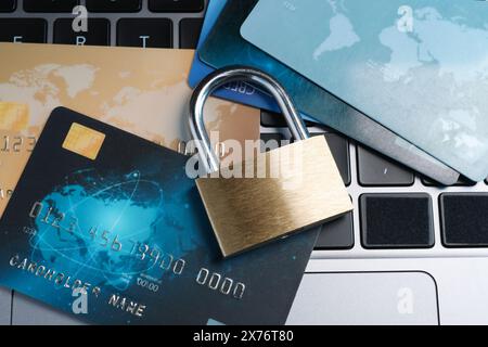 Sicurezza informatica. Lucchetto in metallo e carte di credito sul computer portatile, vista dall'alto Foto Stock