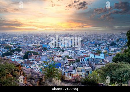 ripresa aerea del drone al tramonto che mostra il paesaggio blu della città di jodhpur mostrando case tradizionali nel mezzo di aravalli con colorate densamente piene Foto Stock