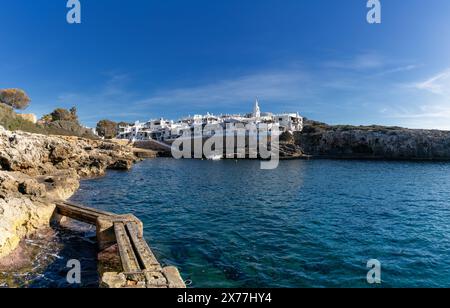 Binibeca Vell, Spagna - 24 gennaio 2024: Insenatura idilliaca e il villaggio imbiancato di Binibeca Vell a Minorca Foto Stock