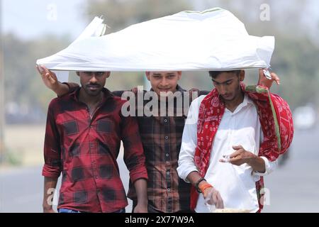 Prayagraj, India. 18 maggio 2024, le persone usano vestiti per proteggersi dal calore rovente durante le condizioni delle ondate di calore in una calda giornata estiva a Prayagraj il sabato. Crediti: Anil Shakya/Alamy Live News Foto Stock