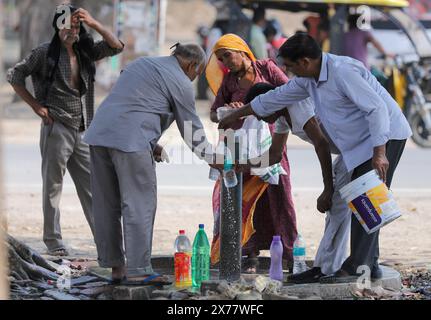 Prayagraj, India. 18 maggio 2024, le persone prendono acqua potabile da un rubinetto sulla strada durante le condizioni di ondata di calore in una calda giornata estiva a Prayagraj il sabato. Crediti: Anil Shakya/Alamy Live News Foto Stock