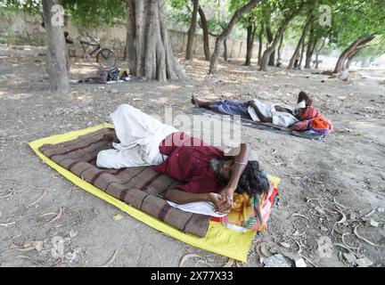 Prayagraj, India. 18 maggio 2024, le persone si riposano sotto gli alberi lungo la strada durante le ondate di caldo in una calda giornata estiva a Prayagraj il sabato. Crediti: Anil Shakya/Alamy Live News Foto Stock