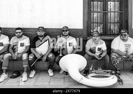 I musicisti riposano all'ombra prima di esibirsi a la Fiesta de la Virgen de la Candelaria, San Pedro de Atacama, regione di Antofagasta, Cile. Foto Stock