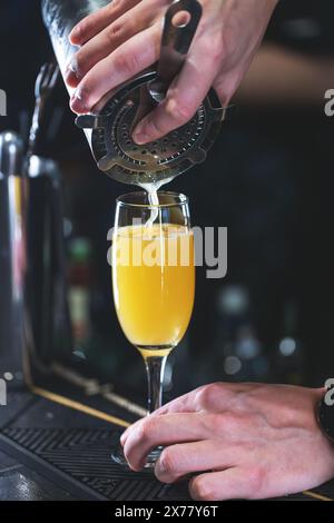 Primo piano di un barista che serve una frizzante mimosa in un bar Foto Stock
