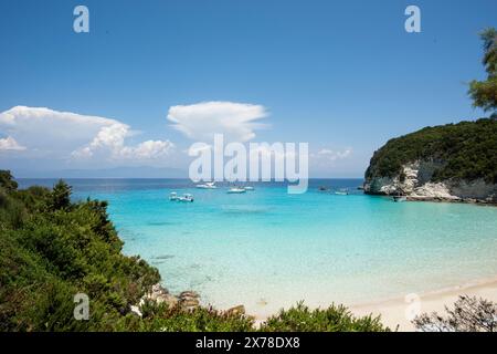 Vista panoramica di una baia rocciosa su un'isola in Grecia con barche ancorate, la costa con molta vegetazione e il Mar Mediterraneo. Viaggi e tour Foto Stock