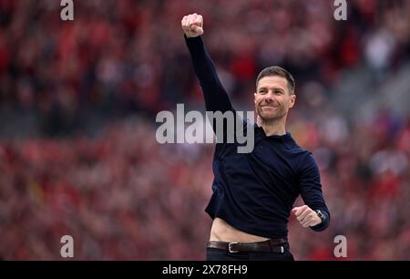 Leverkusen, Germania. 18 maggio 2024. Calcio, Bundesliga, Bayer Leverkusen - FC Augsburg, Matchday 34, BayArena, allenatore Xabi Alonso tifa i tifosi prima di consegnare il trofeo del campionato. NOTA IMPORTANTE: In conformità con le normative della DFL German Football League e della DFB German Football Association, è vietato utilizzare o far utilizzare fotografie scattate nello stadio e/o della partita sotto forma di immagini sequenziali e/o serie di foto video. Credito: Marius Becker/dpa/Alamy Live News Foto Stock