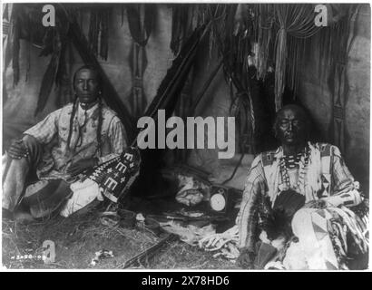 In una loggia Piegan, Curtis no 3088-09., Forms part of: Edward S. Curtis Collection ., pubblicato in: The North American Indian / Edward S. Curtis. [Seattle, Washington.] : Edward S. Curtis, 1907-30, Suppl., v. 6, PL. 188.. Piccolo Plume, famiglia. , Rene giallo, famiglia. , Indiani del Nord America, 1910. , Indiani del Piegan, 1910. , Braids (parrucchiere), 1910. , Calumets, 1910. , Lodges, 1910. Foto Stock