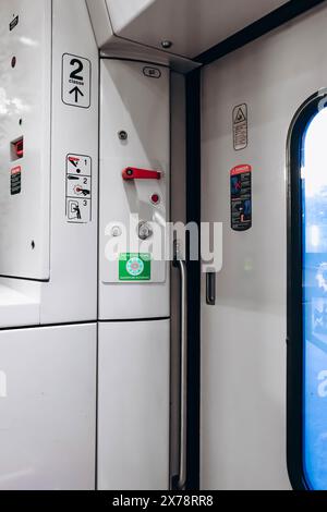 Nizza, Francia - 23 luglio 2023: All'interno del treno SNCF, tipo ter, segnali di avvertimento, valvola di arresto e pulsante di apertura dello sportello nell'area di uscita Foto Stock