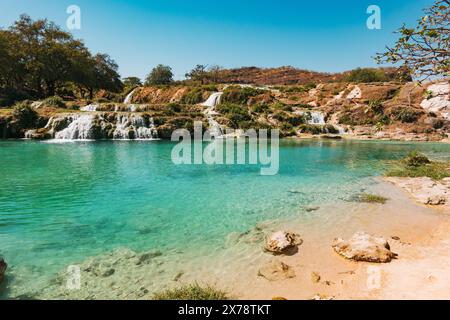 Una vibrante tonalità blu e verdi lussureggianti delle cascate a gradini di Wadi Darbat, Taqah, Oman, una popolare gita di un giorno da Salalah Foto Stock