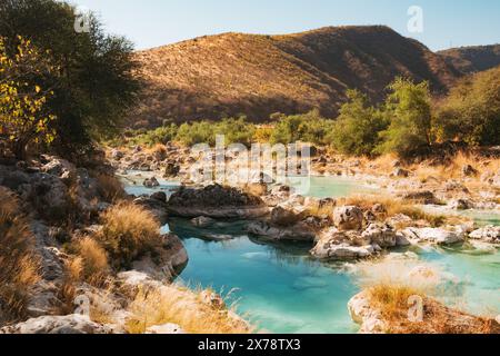 Una vibrante tonalità blu e verdi lussureggianti delle cascate a gradini di Wadi Darbat, Taqah, Oman, una popolare gita di un giorno da Salalah Foto Stock