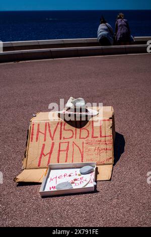 La scultura invisibile della vita di strada dell'uomo - un cappello vuoto e una scatola di monete - umorismo. Francese e inglese. Bene, Provenza, Francia. Divertente... Foto Stock