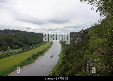 Un fiume con una barca sopra e un cielo nuvoloso sullo sfondo Foto Stock