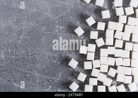 Raffinati cubetti di zucchero su sfondo grigio Foto Stock